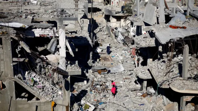 Children walk among destroyed buildings in Khan Younis in southern Gaza