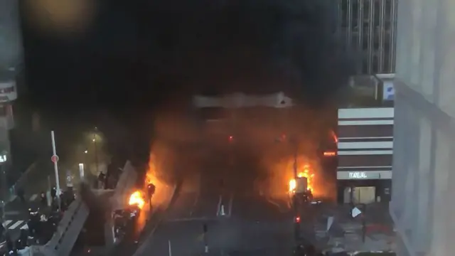 A picture shows vehicles and bins burning in a street aside the Gare de Lyon rail station in Paris on February 28, 2020.