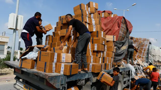 Palestinians reload a truck with aid that fell from the vehicle, amid shortages of food supplies, during the ongoing conflict between Israel and Palestinian Islamist group Hamas, in Rafah in the southern Gaza Strip, November 2, 2023