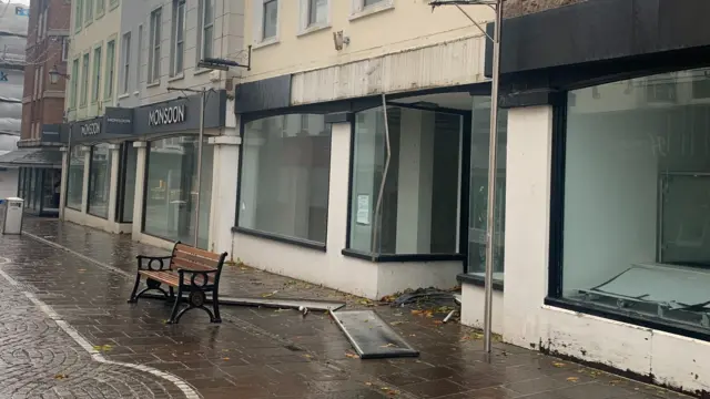 A damaged shop front on Queen Street in St Helier, Jersey