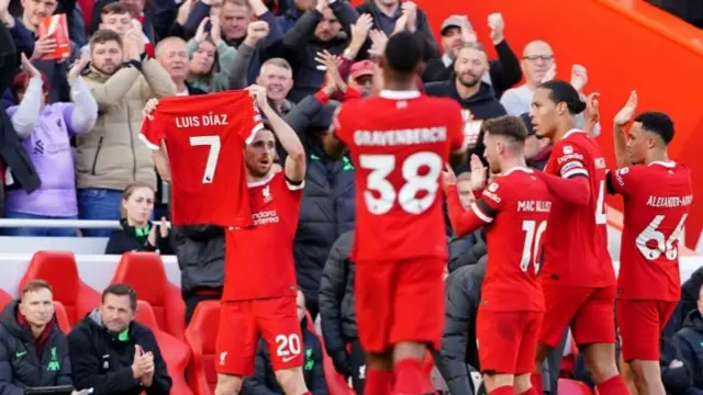 Diogo Jota holds up a Luis Diaz shirt to show his support for his Liverpool team-mate