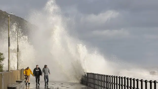 Waves crash against the promenade in Folkestone