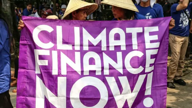 Protesters hold a sign reading "Climate Finance Now" during a demonstrationin Manila on September 29, 2023,