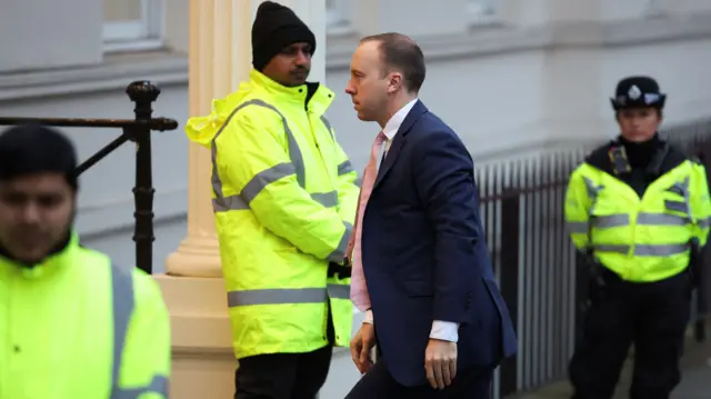 Matt Hancock walking past security to enter a building