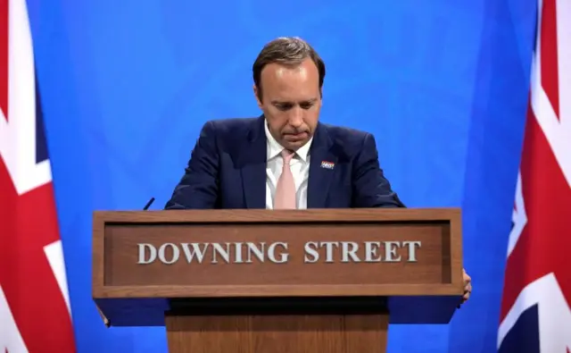 Matt Hancock speaking at Covid press briefing from plinth that says "Downing Street"