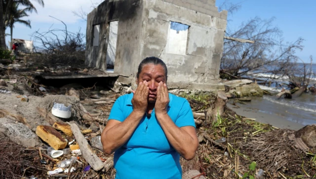 Celia Figarola cries in front of what is left of her house as rising sea levels are destroying homes built on the shoreline and forcing villagers to relocate, in El Bosque, Mexico