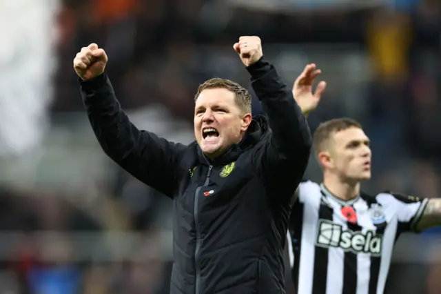 Eddie Howe throws his fists in the air in celebration, Trippier does the same in the background.