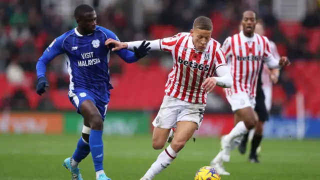 Cardiff's Jamilu Collins (left) challenges Stoke for the ball