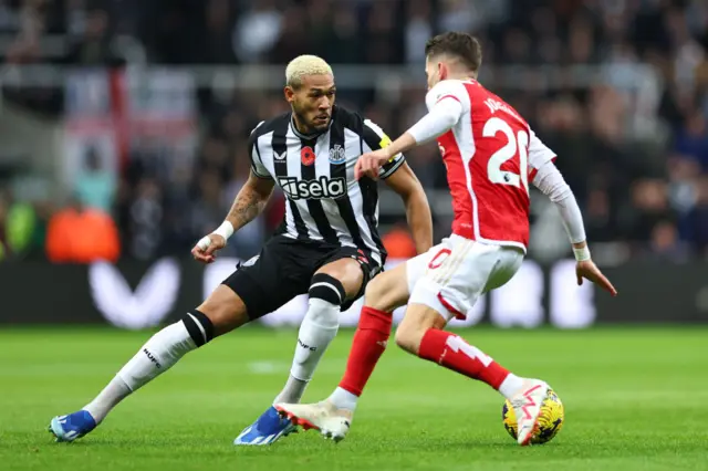 Joelinton looks to dribble past Jorginho in the midfield.