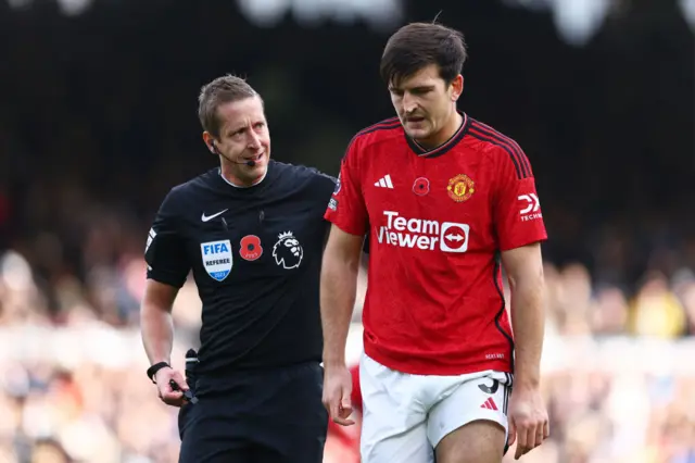 Referee John Brooks checks Harry Maguire