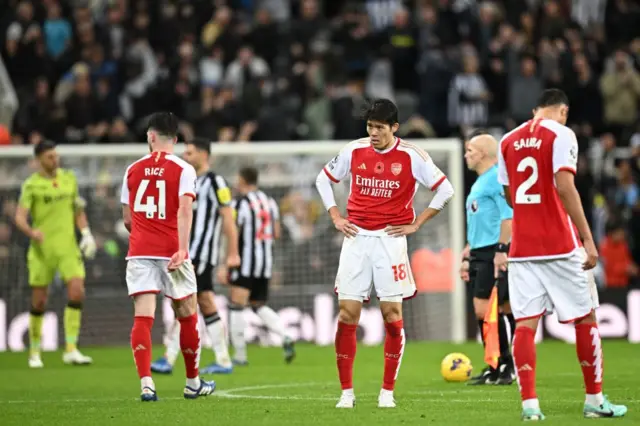 Arsenal players stand shellshocked after their loss to Newcastle