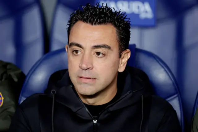 Xavi looks on concerned from the dugout.