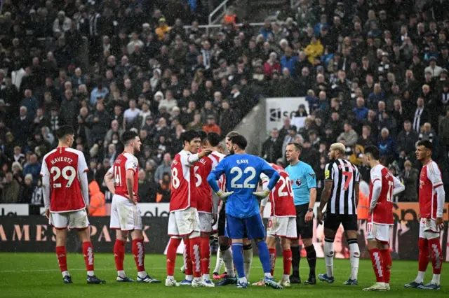 PLayers surround the ref after a controversial goal for Newcastle.