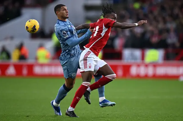 Diego Carlos (L) clashes with Nottingham Forest's Swedish midfielder #21 Anthony Elanga