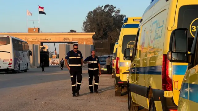 Egyptian Ambulance Organisation's workers walk past parked ambulances near the Rafah border crossing. 4 November