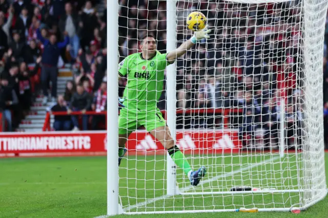 Emiliano Martinez of Aston Villa attempts to save the goal scored by Orel Mangala