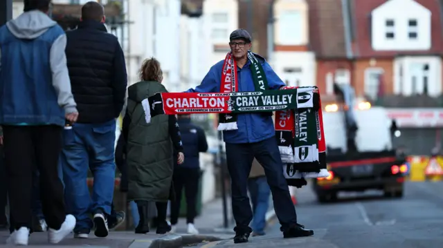 Man holds Charlton and Cray Valley scarf