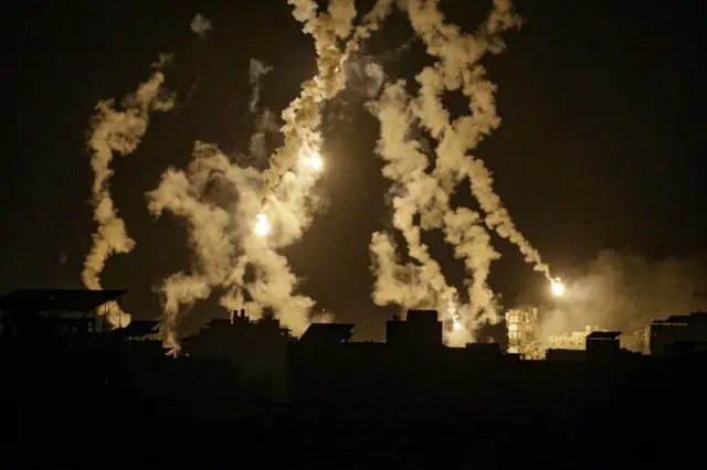 Israeli army flares illuminate the sky over Al-Shati refugee camp during an exchange of fire between the Israeli army and Hamas