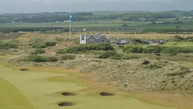 A wide view of Trump's golf resort in Aberdeenshire in north-east Scotland. A Scottish flag and grey building can be seen at the side of the golf course