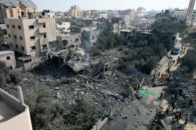 Palestinians gather at the site of an Israeli strike on a house in Deir Al-Balah