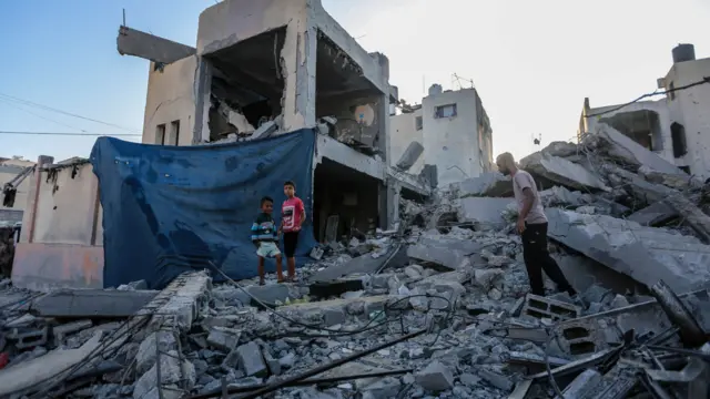 People search through buildings, destroyed during Israeli air raids in the southern Gaza Strip on November 6, 2023 in Khan Yunis, Gaza. The Israeli army has expanded its military assault. The Gaza strip, a besieged Palestinian territory, is under heavy bombing from Israel in response to the large-scale attack carried out on October 7 by Hamas in Israel. The international community is stepping up pressure for a humanitarian truce. (Photo by Ahmad Hasaballah/Getty Images)