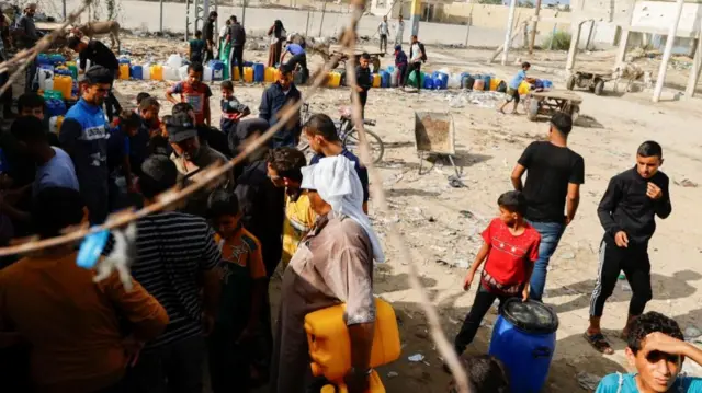 Palestinians collect water amid a lack of clean and drinking water, as the conflict between Israel and Hamas continues