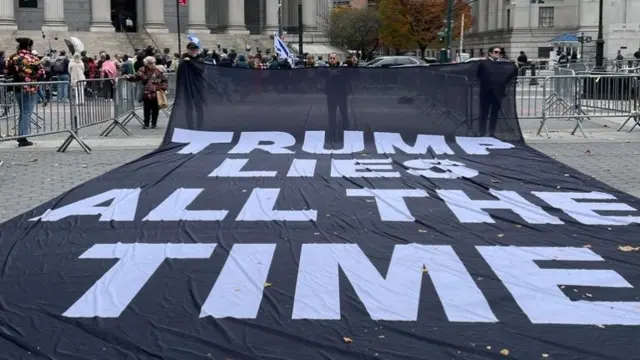 A sign saying Trump lies all the time which is in front of a New York courthouse