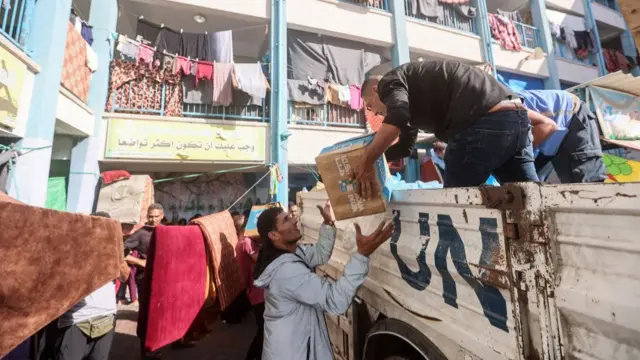 UN workers and volunteers unload aid from a truck