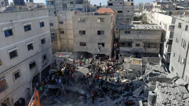 Palestinians search for casualties at the site of an strike on a house