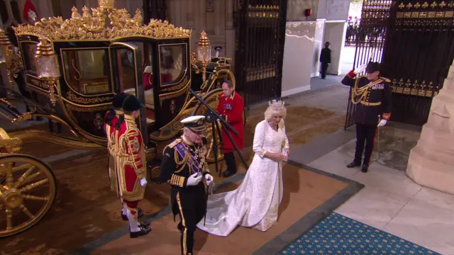 The King and the Queen leave the carriage and head into Parliament