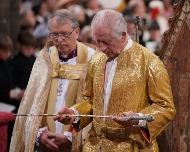 King Charles holding the Sword of State at his coronation ceremony