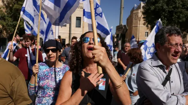 People hold Israeli flags on the day of a ceremony in memory of the victims, on the one-month anniversary of the attack by the Palestinian Islamist group Hamas on October 7th, in Jerusalem November 7, 2023