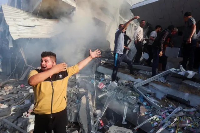 Palestinians react at the site of Israeli strikes on a residential building, amid the ongoing conflict between Israel and Palestinian Islamist group Hamas, in Khan Younis in the southern Gaza Strip, November 7, 2023