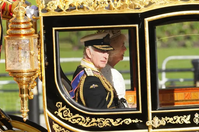 King Charles and Queen Camilla sit in the carriage