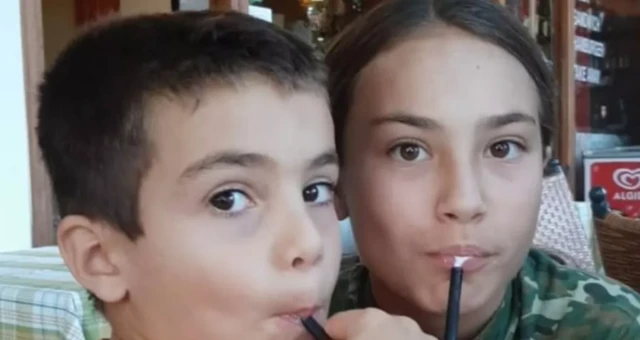 Two children drinking via straws