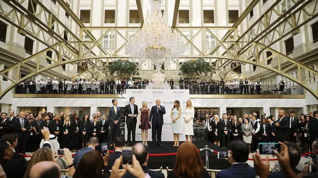 Donald Trump (C) and his family (L-R) son Donald Trump Jr, son Eric Trump, wife Melania Trump and daughters Tiffany Trump and Ivanka Trump prepare to cut the ribbon at the new Trump International Hotel in 2016 in Washington, DC.