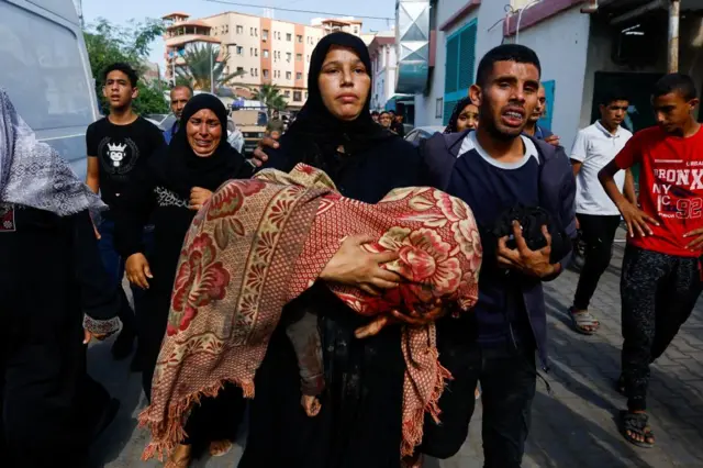 A woman carrying an injured child in Khan Younis on Wednesday morning