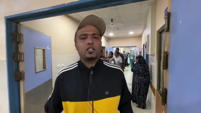 Mohammed Abu Daqa speaking in a hospital corridor