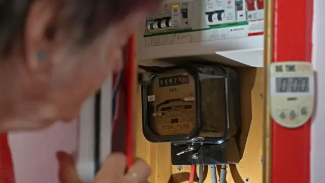 Old woman working an electric meter