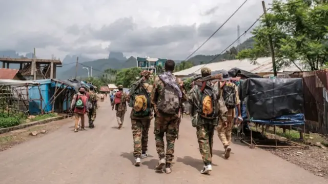 Members of the Amhara militia walk in a street of the village of Adi Arkay, 180 kilometers northeast from the city of Gondar, Ethiopia, on July 14, 2021.