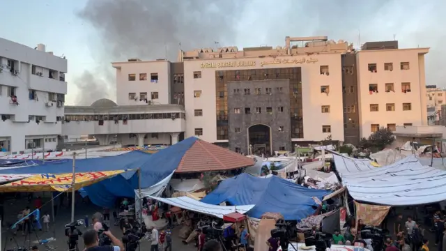 Smoke rises as displaced Palestinians take shelter at Al Shifa hospital, amid the ongoing conflict between Hamas and Israel, in Gaza City, November 8, 2023