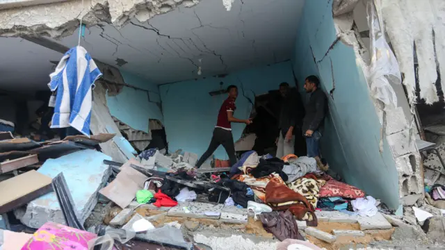 People search through buildings, destroyed during Israeli air raids in the southern Gaza Strip on November 9, 2023 in Khan Yunis, Gaza. Heavy fighting rages in the northern Gaza Strip as Israel encircles the area, despite increasingly pressing calls for a humanitarian truce. The leaders of the main UN agencies issued a rare joint statement to express their indignation. More than 40 per cent of the dead in Gaza after nearly four weeks of war are children. (Photo by Ahmad Hasaballah/Getty Images)