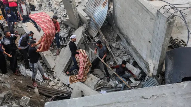 People search through buildings, destroyed during Israeli air raids in the southern Gaza Strip on November 9, 2023 in Khan Yunis,