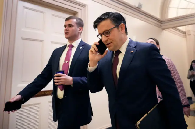 Speaker of the House Mike Johnson leaves a caucus meeting ahead of a vote to expel George Santos