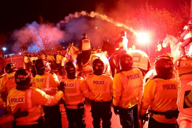 Police confront Legia Warsaw fans while a missile goes through the air