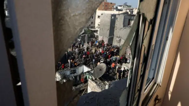 Palestinians inspect the site of Israeli strikes on houses in Khan Younis after a temporary truce between Hamas and Israel expired