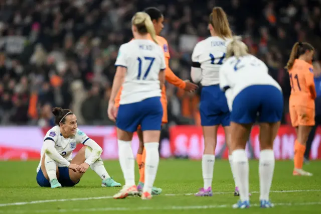 England players sit on the pitch at full time.