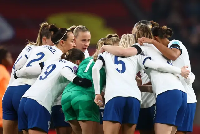 England players huddle before kick off in the second half.