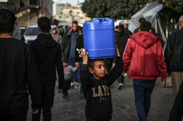 A child carries a water tank in Khan Younis, 9 December 2023