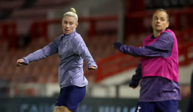 Beth England warms up alongside a teammate for Spurs.